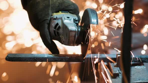 Man Works with Circular Saw. Sparks Fly From Hot Metal. Man Hard Worked Over the Steel. Industrial