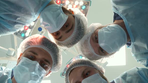 Surgical Team Bends Over the Patient