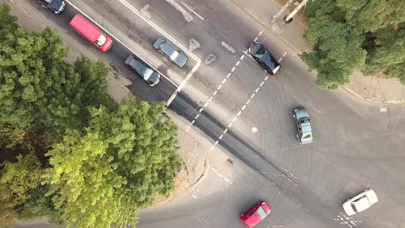 Top down aerial view of city traffic with cars moving on a street at roads intersection.