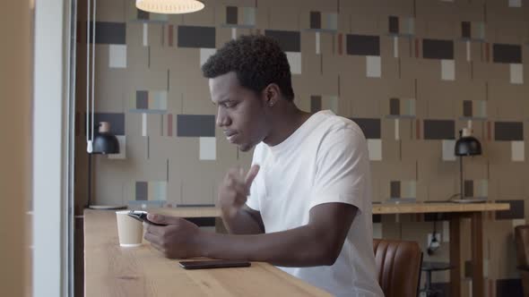 Focused Young African American Guy Using Tablet