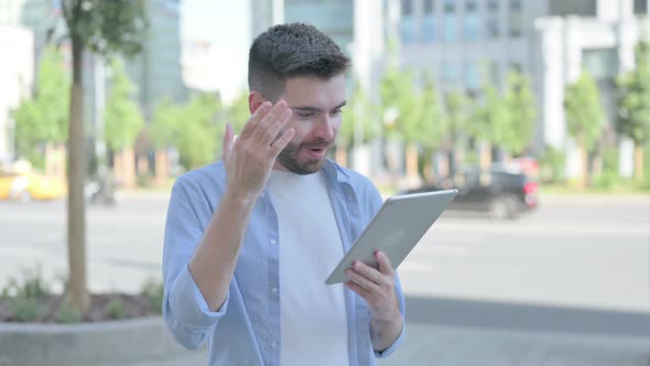 Young Man Celebrating Online Win on Tablet Outdoor