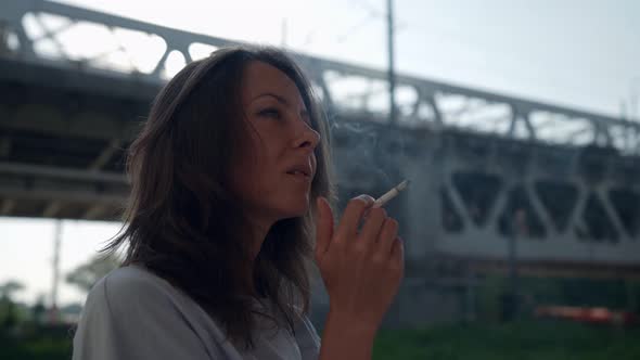 Happy Smoking Woman is Exhaling Smoke and Smiling to Camera Portrait of Lady Outdoors