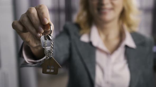 Midsection of Senior Estate Agent Presenting Keys
