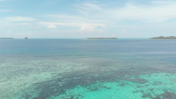 Aerial: flying over desert island tropical beach caribbean sea turquoise water c