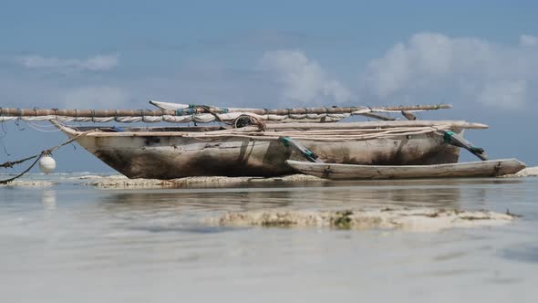 African Traditional Wooden Boat Stranded in Sand on Beach at Low Tide Zanzibar