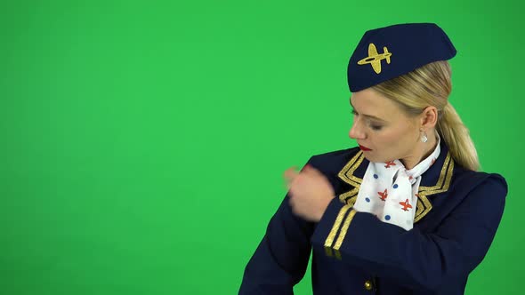 A Young Beautiful Stewardess Fixes Her Uniform and Smiles at the Camera - Green Screen Studio