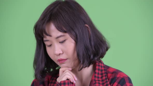 Face of Stressed Asian Hipster Woman Thinking and Looking Down