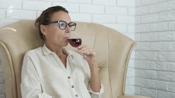 A woman is enjoying a glass of wine.