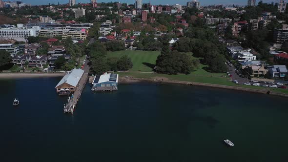 Sydney Harbor on a beautiful sunny day from Double Bay featuring boats, blue sky and water. Drone fl