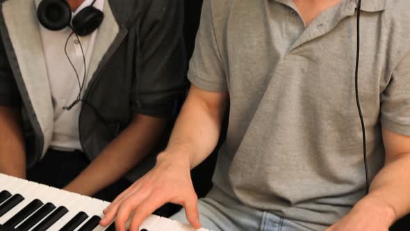 Two students playing on keyboard