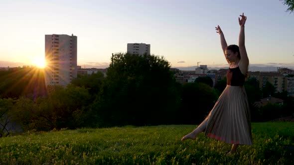 Young woman turning wheels at viewpoint during sunset