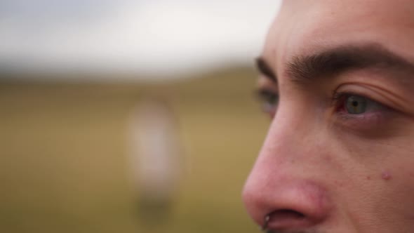 A Porter of a Man in a Field with Blue Eyes a Beard Who Looks Into the Horizon