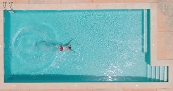 View From the Top As a Man Dives Into the Pool and Swims