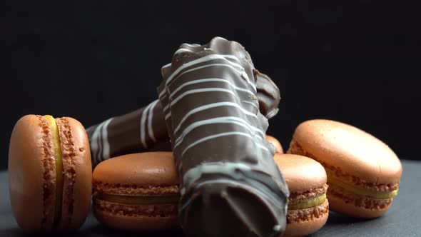 Chocolate and Macaroon Rotate on a Black Background Tasty Candys Sweets are Spinning Macro