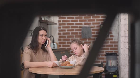 Mother with Child in the Kitchen Drinking Tea