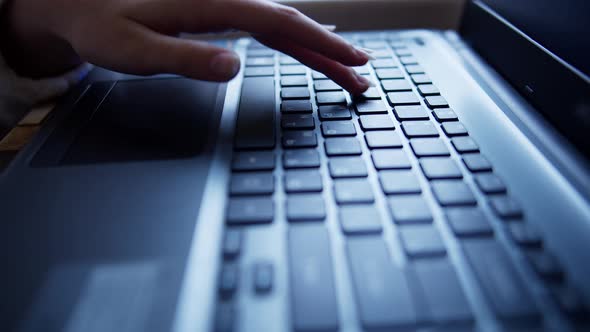 Teen girl learning to type on a laptop keyboard, close-up, rack focus