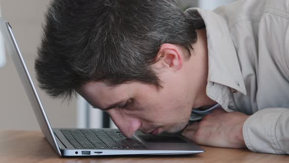 Portrait of Caucasian Man Millennial Lazy Worker Sleeping Lies on Laptop in Office at Table at