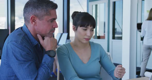 Man and young woman working on computer