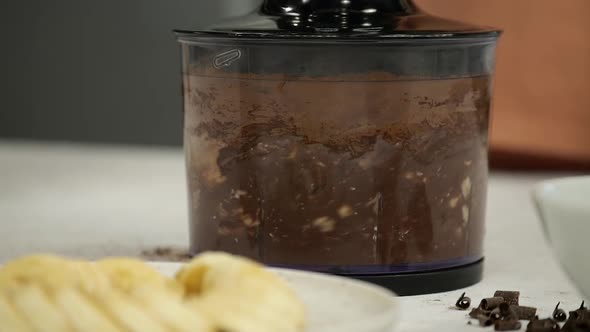 Close-up of a chocolatey mixture blending in a food processor.