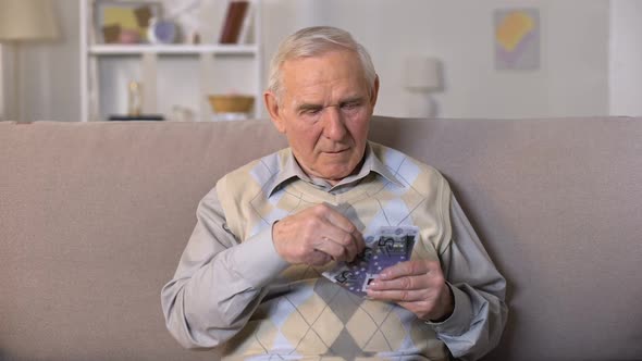 Upset Aged Man Sitting on Sofa, Holding Euros Banknotes, Social Insecurity