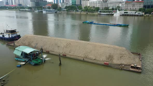 Aerial shot of Ho Chi Minh City waterfront with tug, barges and other boats working on the Saigon Ri