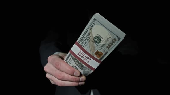 Stack of 10000 American Dollars in Bundle in Male Hands on Black Background