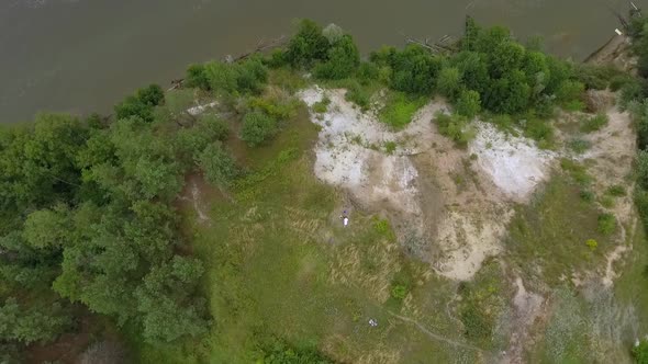 Aerial View of Three Girlfriends Dancing and Spinning Around on a High Hill at the River