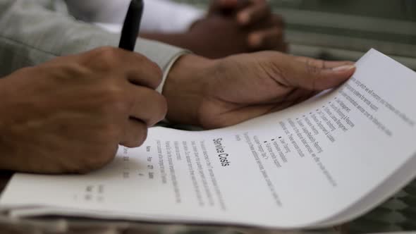 Cropped Shot of Male Hands Signing Documents