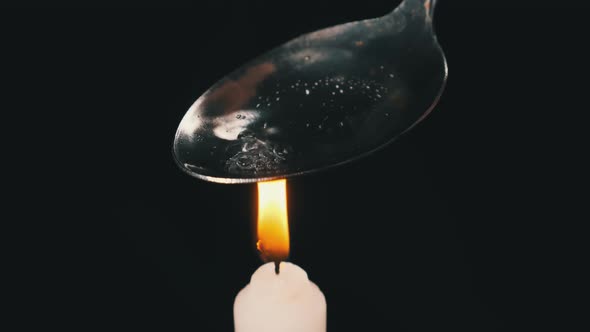 Cooking Heroin on a Spoon Over the Flame of Candle. Prepares a Dose. Hard Drugs