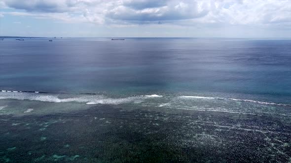 Aerial : Flight Over The Ocean And giant container ship in background