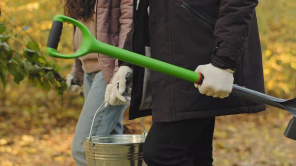 Closeup Unrecognizable People Ecoactivists Landscapers Walk in Autumn Park Hold Shovel and Bucket