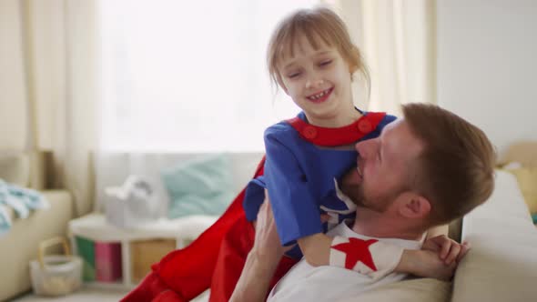 Daughter Sitting on Father Laps Hugging