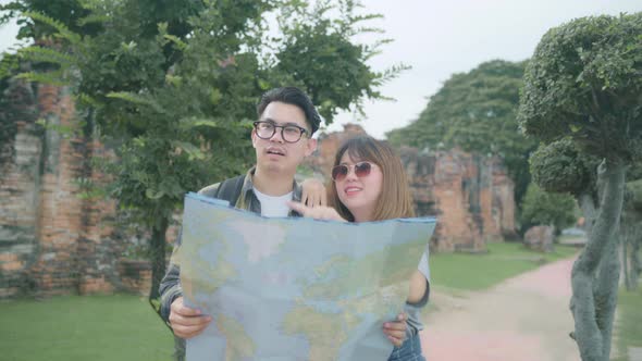 Asian couple direction and looking on location map while spend holiday trip at Ayutthaya Thailand