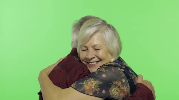 Elderly Man Hugging a Senior Woman and She Falls on His Shoulder. Chroma Key