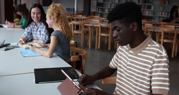 Multiracial young students learing together inside school library