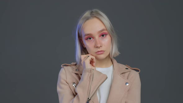 Serious Hipster Woman Isolated on Grey Studio Background. Portrait of Tired Lady