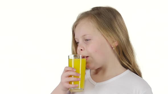 Children Drinks Orange Juice, It Is Very Tasty. White Background. Slow Motion