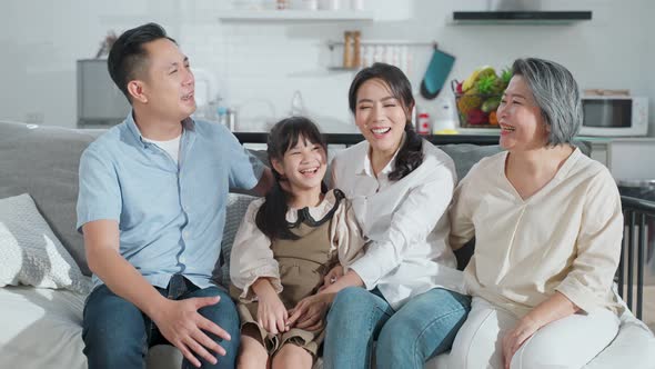 Portrait of Asian family Father mother and young kid looking at camera with smile together at home.