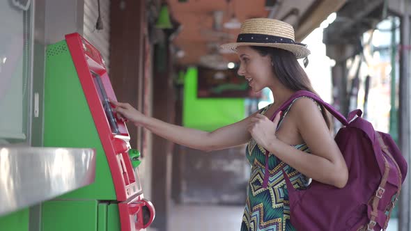 Young Brunette Girl Traveler Withdrawing Money From ATM in Thailand Asia