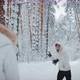 A Guy with a Girl Playing Snowballs in Winter Forest - VideoHive Item for Sale