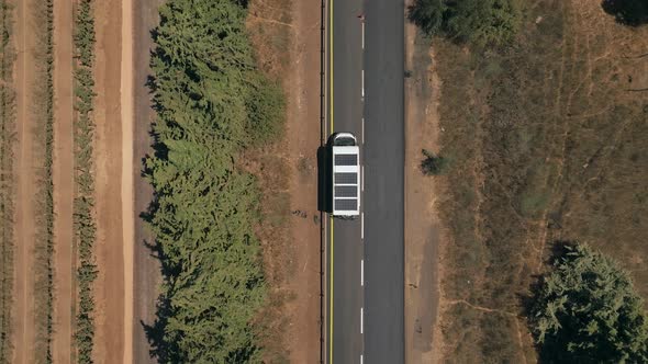 Camper van with Solar panels driving on a countryside road.