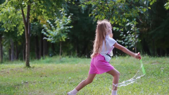 Little girl blowing soap bubbles. Funny lovely little girl blowing soap bubbles in park