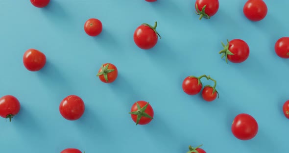 Video of fresh cherry tomatoes on blue background