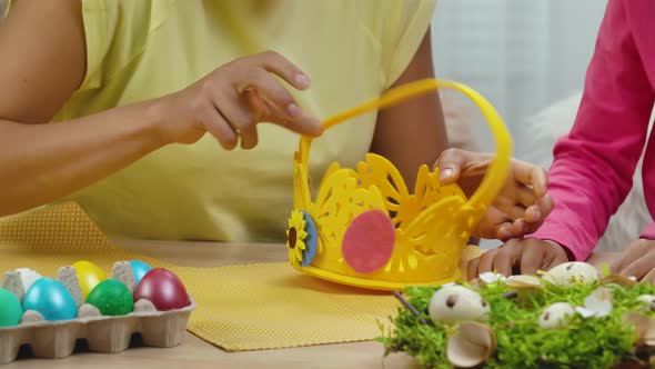 Mom and Daughter with Funny Bunny Ears Decorate Egg Basket
