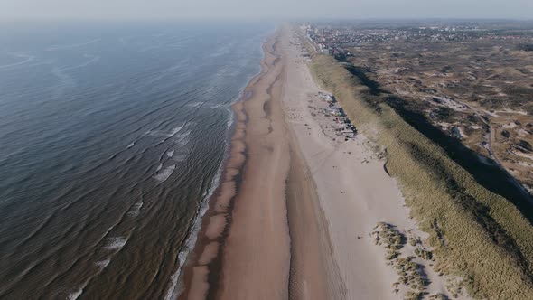 Drone Flies Over Ocean Shore Outside the City on a Sunny Day