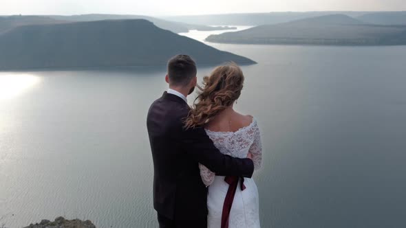 Magical and Mystical Couple Looks at the Coast From a Cliff