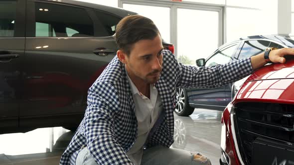 An Attentive Customer Is Studying the Bumper of His New Car