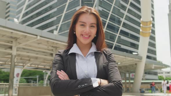 Portrait of Asian young smart businesswoman stand with smile in city while walk to company office.
