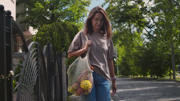 Woman Carrying Groceries In Reusable String Bag