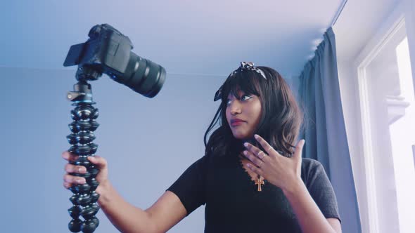 Cheerful Young African American Female Blogger Holding Camera and Recording Video for Vlog While